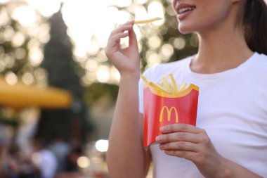 Lviv, Ukrayna - 26 Eylül 2023: McDonald 's' ın patates kızartması olan kadın, yakın plan. Metin için boşluk