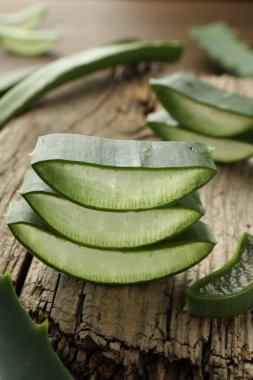 Taze aloe vera dilimleri ahşap masada, yakın plan.