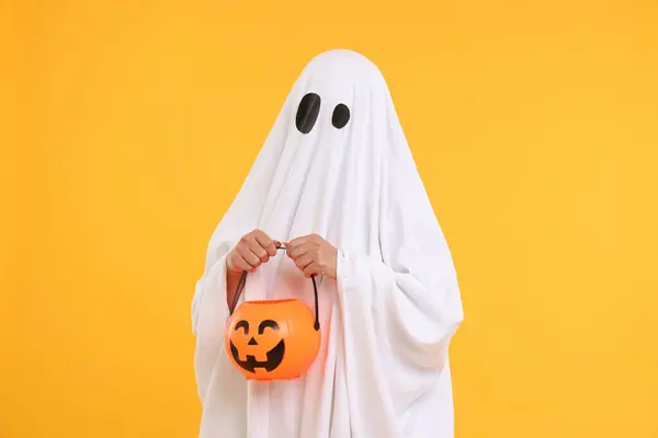 Fehér Szellem Jelmezes Sütőtök Vödröt Tart Sárga Háttérben Halloween Ünnepe — Stock Fotó