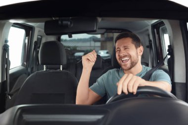 Radyo dinliyordum. Arabadaki müzikten hoşlanan yakışıklı adam, ön camdan bakıyor.