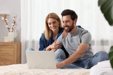 Evde dizüstü bilgisayarı olan mutlu çift.