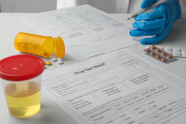 Laboratory worker filling drug test result form at table, closeup clipart