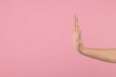 Pembe arka planda dur hareketi gösteren bir kadın, yakın plan. Metin için boşluk