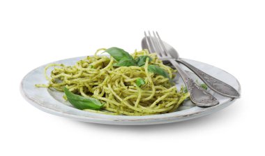 Beyaz arka planda pesto soslu lezzetli makarna, fesleğen ve çatal bıçak.