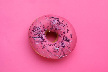 Tatlı jöleli donut, pembe arka plan üzerine serpiştirilmiş, üst manzara. Lezzetli şekerlemeler.