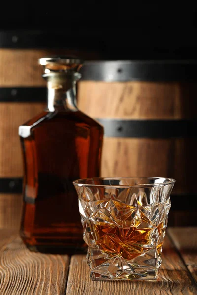 stock image Glass and bottle of tasty whiskey on wooden table