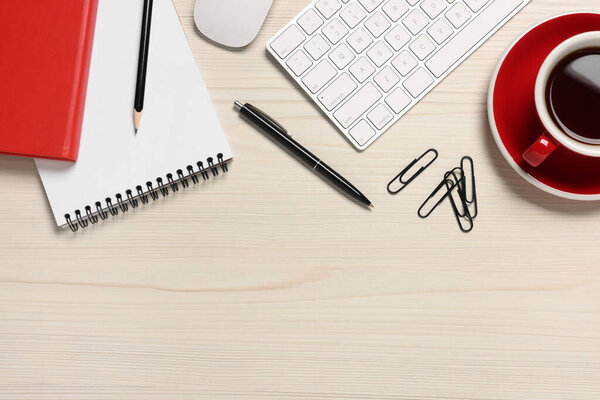 Flat lay composition with computer keyboard and different stationery on white wooden desk, space for text. Home office