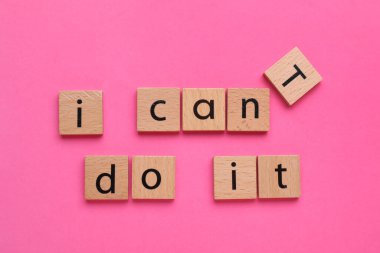 Motivasyon konsepti. I Can 't Do It' ten I Can 't Do It' e geçiş cümlesini pembe arkaplandaki T harfi ile ahşap kareyi kaldırarak değiştiriyorum.