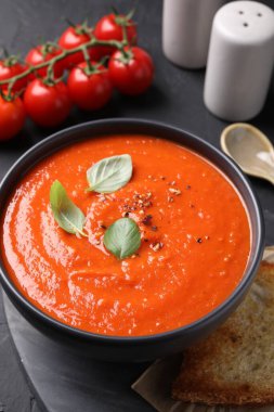 Siyah desenli masada servis edilen lezzetli domates kremalı çorba.
