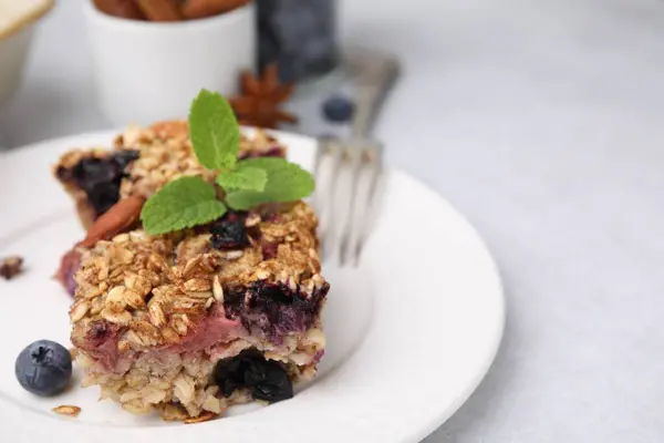 Tasty baked oatmeal with berries on light table, closeup