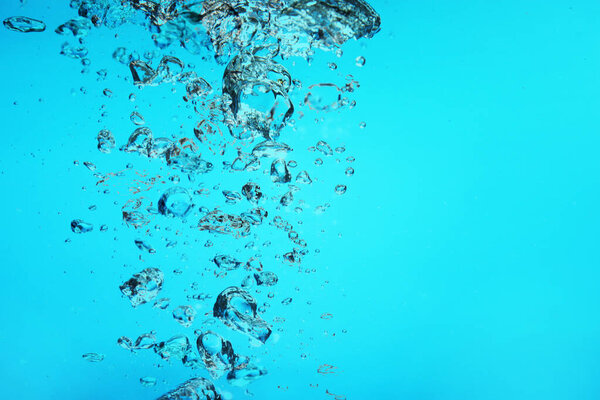 Много пузырьков воздуха в воде на светло-голубом фоне, пространство для текста