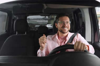 Radyo dinliyordum. Arabadaki müzikten hoşlanan yakışıklı adam, ön camdan bakıyor.