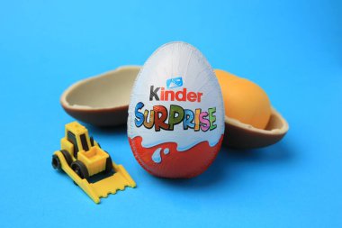 Sveti Vlas, Bulgaristan - 29 Haziran 2023: Kinder Sürpriz Yumurtaları, plastik kapsül ve açık mavi arka planda oyuncak