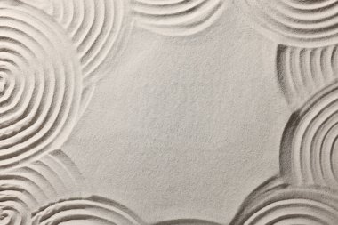 Kum üzerine çizilmiş güzel çizgilerin çerçevesi, üst manzara ve metin için boşluk. Zen bahçesi