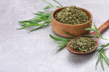 Açık gri desenli masa üzerinde kuru ve taze tarhun otu, metin için boşluk