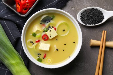 Gri masada servis edilen soya peynirli miso çorbası.