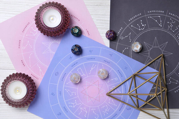 Astrology prediction. Flat lay composition with zodiac wheels on white wooden table