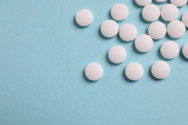 Açık mavi arka planda bir sürü beyaz hap var. Metin için boşluk