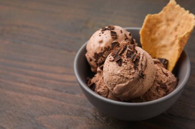 Lezzetli çikolatalı dondurma ve bir parça waffle külahı ahşap masada, yakın plan. Metin için boşluk