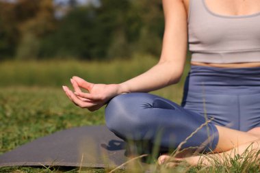 Paspasda yoga yapan bir kadın, yakın çekim ve mesaj için yer. Lotus pozu