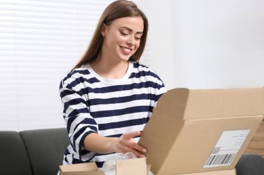 Evde paketleri açan mutlu kadın. Çevrimiçi mağaza