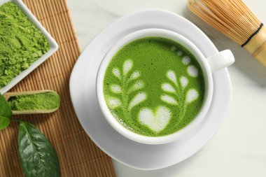 Delicious matcha latte, powder, leaf and whisk on white table, flat lay clipart