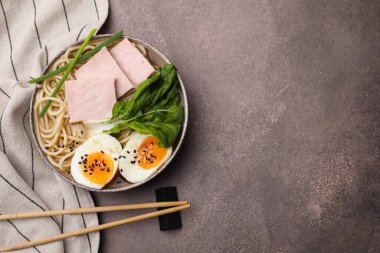 Gri masada servis edilen lezzetli ramen, düz yatak ve yazı için yer. Erişte çorbası.