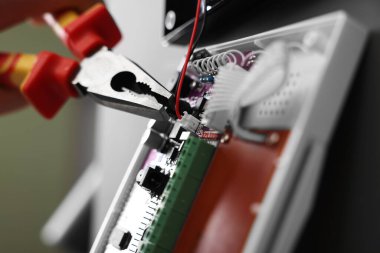 Kara duvara pense yerleştirilirken pense kullanılıyor, seçici odak