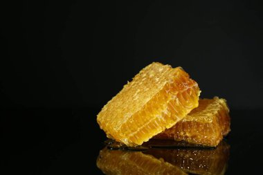 Siyah zemin üzerinde lezzetli bal bulunan doğal bal petekleri, metin için boşluk