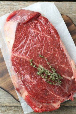 Tahta masada çiğ et ve kekik var.