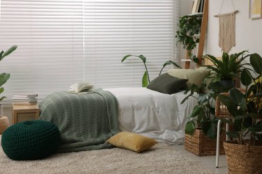 Büyük, rahat bir yatak odası ve şık bir yatak odasında saksı çiçekleri. İç tasarım