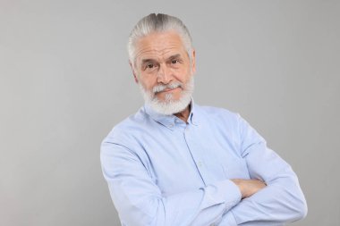 Açık gri arka planda yakışıklı yaşlı adamın portresi