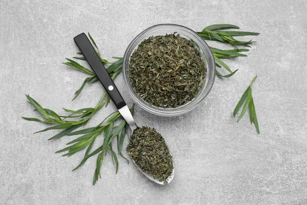 Dry and fresh tarragon on light gray textured table, flat lay