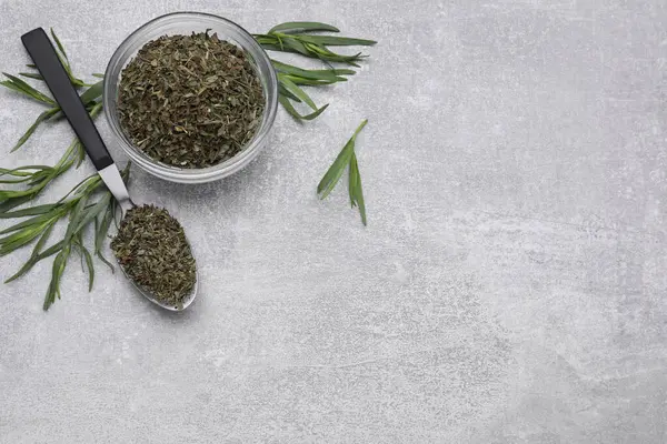 Dry and fresh tarragon on light gray textured table, flat lay. Space for text