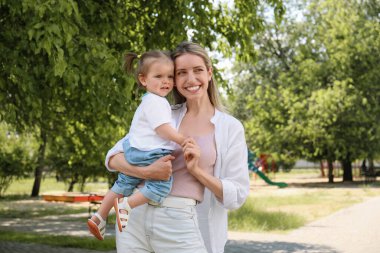 Happy mother with her daughter spending time together in park