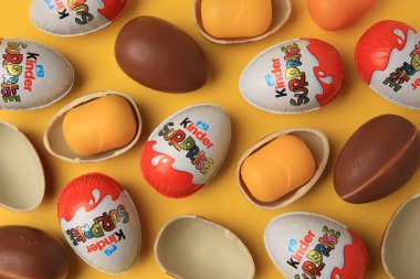 Sveti Vlas, Bulgaristan - 29 Haziran 2023: Turuncu zemin üzerinde Kinder Sürpriz Yumurtalar ve plastik kapsüller, düz yatar
