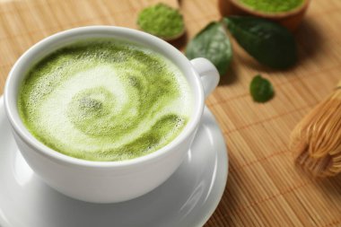 Bambu hasırının üzerinde fincanda nefis bir matcha latte, yakın plan. Metin için boşluk
