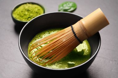 Gri masada bir fincan kibrit çayı ve bambu çırpısı, yakın plan.