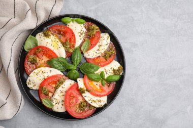 Gri masadaki pesto soslu lezzetli Caprese salatası. Metin için boşluk