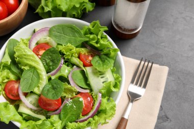 Gri masada servis edilen lezzetli sebze salatası.