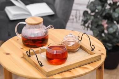 Çaydanlık, bir fincan aromatik çay ve kahverengi şeker.