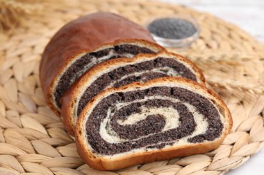 Hasır üzerinde haşhaş tohumu rulosu kes, yakın plan. Pasta nefis.