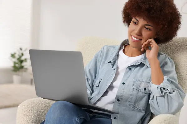 stock image Young woman using modern laptop in room