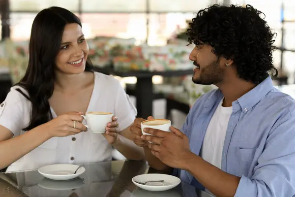 International dating. Happy couple enjoying tasty coffee in cafe