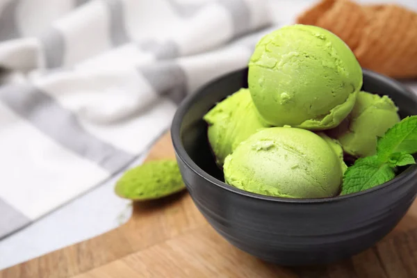 Tasty matcha ice cream in bowl on table, closeup. Space for text
