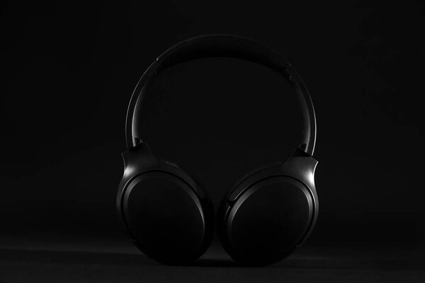Стильные современные беспроводные наушники на черном фоне
