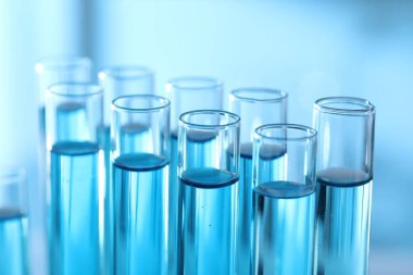 Laboratuvarda açık mavi sıvıyla test tüpleri, yakın plan.