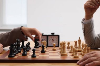 Erkekler turnuva sırasında kapalı mekanlarda satranç oynuyorlar.