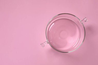 Pembe arka planda boş cam kap, üst manzara. Metin için boşluk