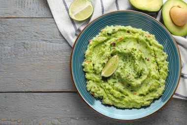 Limonlu guacamole ve gri ahşap masa üzerinde taze avokado. Metin için boşluk